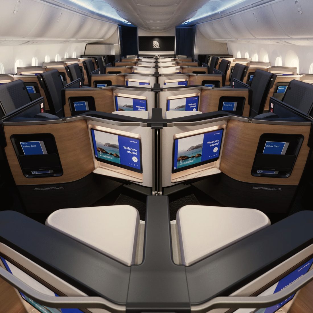 A United Polaris business class cabin, suites with doors and wood panelling, daylight at the windows